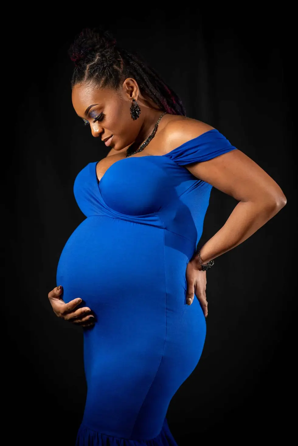 Studio maternity portrait in royal blue against a black backdrop by Ken Floyd Media